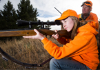 Deer hunter aiming her rifle