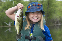 Girl holding up a fish she caught