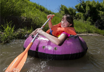 Young girl tubing with a paddle