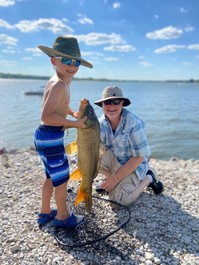 Boy and his dad holding up a fish