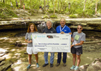 Shannon Vanderheiden and Game and Parks staff holding a check announcing the funds