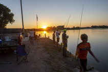 Anglers fishing on Spalding Dam at sunset