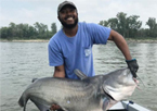 Kirbian Peters holding a record-size blue catfish