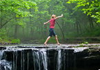 Girl walking across waterfall at Platte River State Park