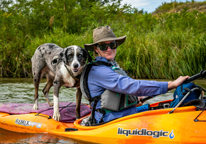 A woman kayaking with her dog