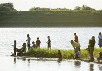 People fishing along the shoreline at Community Fishing Night