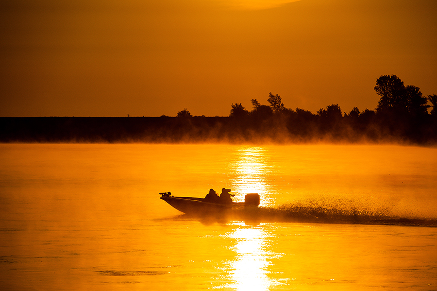 Boating on the Missouri River during a vibrant orange sunset.