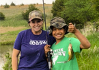 Woman and boy holding up a fish