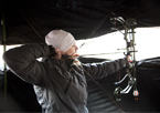 Woman bowhunting from a blind