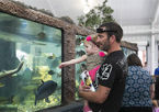 Father and young daughter looking at aquarium at Game and Parks' state fair exhibit