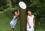 Two girls standing by a Great Park Pursuit post