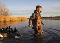 Boy dragging decoys in lake