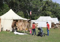 People standing by white tents at Ash Hollow