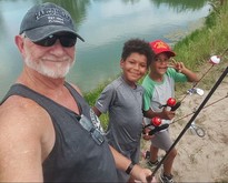 Senior man fishing with two kids