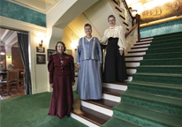 Women in period clothing standing inside Arbor Lodge Mansion