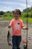 Young boy holding a catfish he caught