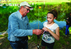 A youth fishing instructor working with a girl