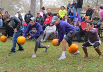 People rolling pumpkins