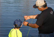 Youth fishing instructor working with a child