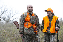 Two deer hunters smiling in the field