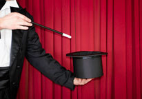 Magician with hat in front of red curtain