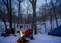 Camper by the fire in snowy landscape at Indian Cave State Park