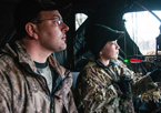 Father and son hunting turkeys in a blind