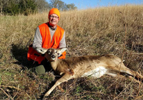 Hunter posing next to harvested deer