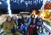 People on a hayrack ride decorated with Christmas lights