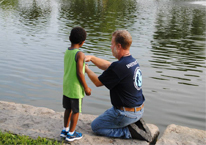 Youth fishing instructor working with a child.