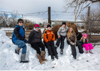 People pause on a First Day Hike to sit in the snow