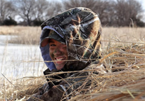 Young woman smiling while waterfowl hunting