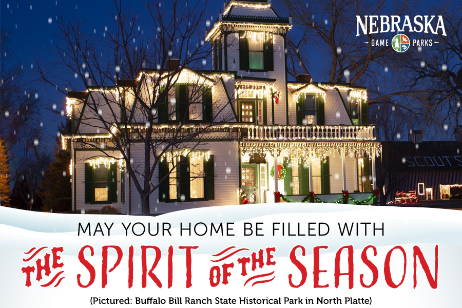 Buffalo Bill's mansion decorated with Christmas lights and text, "May your home be filled with the spirit of the season."