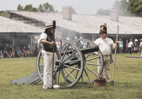 Living history reenactors firing a cannon at Fort Atkinson State Historical Park