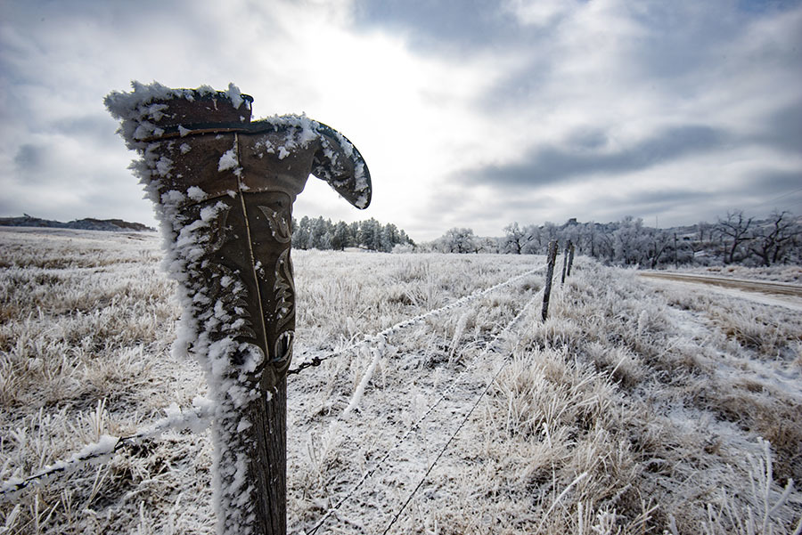 Frosty cowboy boot sits on top of a fence post in Dawes County