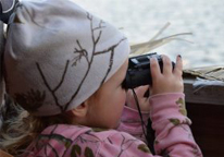 Little girl using binoculars at Marsh Madness event