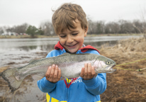 Boy holding up a rainbow trout