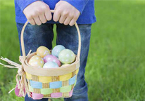 Closeup of child holding Easter egg basket with eggs in it