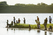 People fishing from the shore at a Community Fishing Event