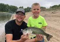 Father and son holding up a fish