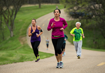 People running on a road at a park