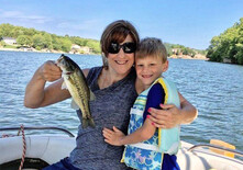 Mother and son holding up fish on a boat