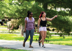 Two friends walking on a path at a park