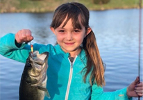 Little girl holding up a fish