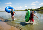 Boys wearing life jackets playing in water