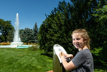 Girl making a rubbing at Great Park Pursuit post