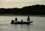 Anglers fishing from a boat at sunset at Summit Lake