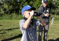 Boy looking for birds through binoculars