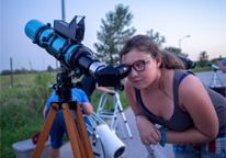 Girl looking at sky through telescope