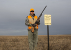 Hunter standing next to Open Fields and Waters sign